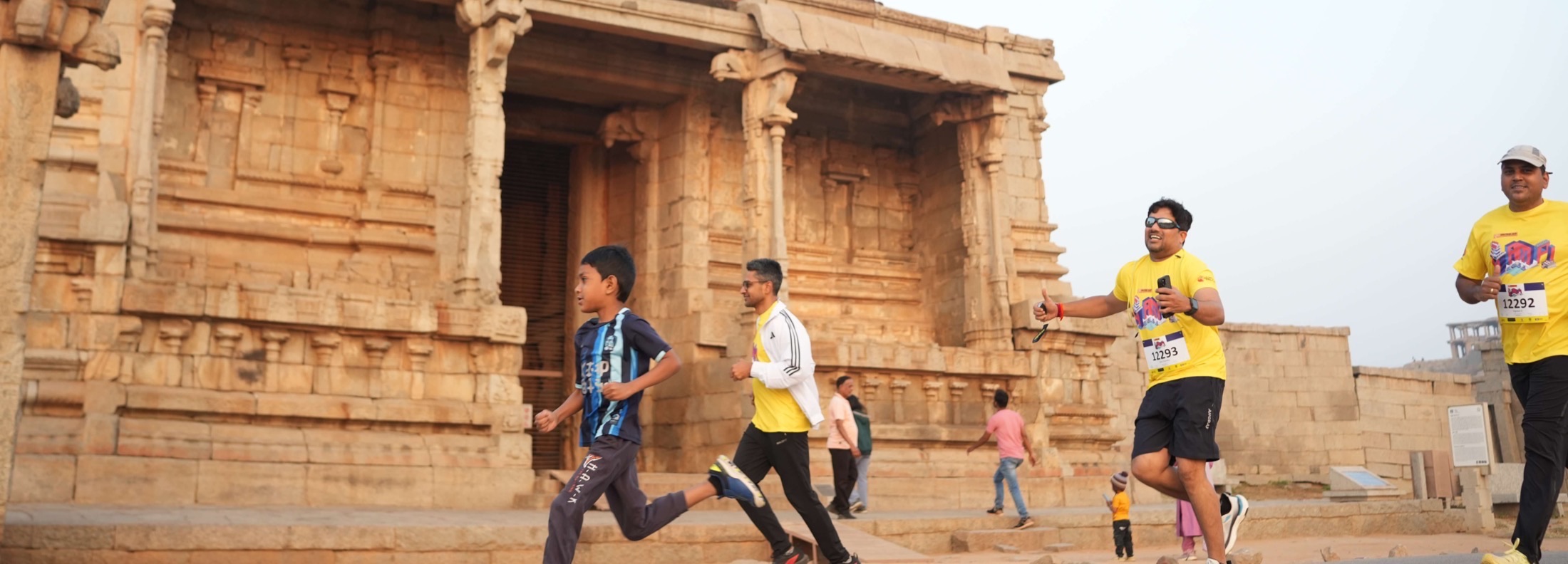 Runners, including a boy, pass the Krishna Temple in the early morning